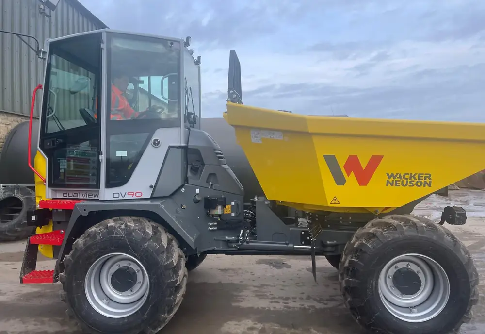 A Wacker Neuson DV90 dual-view forward tipping dumper with the operator at the controls
